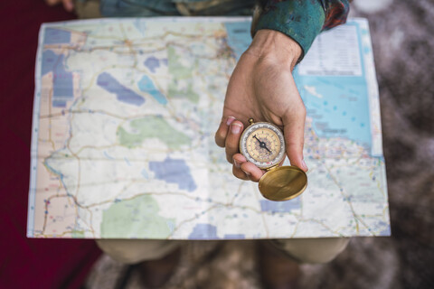 Hand hält Kompass über Karte, lizenzfreies Stockfoto