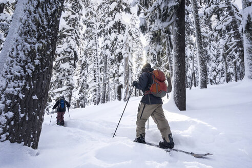 Männliche Freunde beim Skifahren auf einem schneebedeckten Berg - CAVF51030