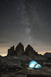 Illuminated tent on mountain against star field at night - CAVF51043