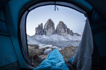 Tiefschnitt eines Mannes mit Decke im Zelt auf einem Berg bei Sonnenuntergang - CAVF51044