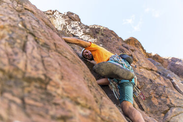 Low angle view of hiker climbing mountain - CAVF51086