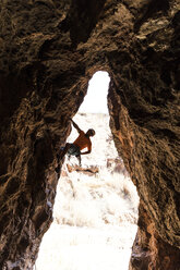 Wanderer beim Klettern auf eine Felsformation in der Wüste - CAVF51087