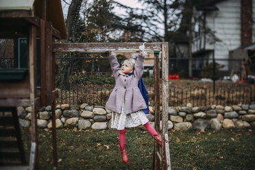 In voller Länge von Mädchen hängen auf Monkey Bars beim Spielen auf dem Spielplatz im Herbst - CAVF51150