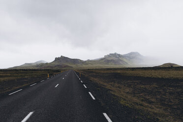 Empty road leading towards mountain against cloudy sky - CAVF51157