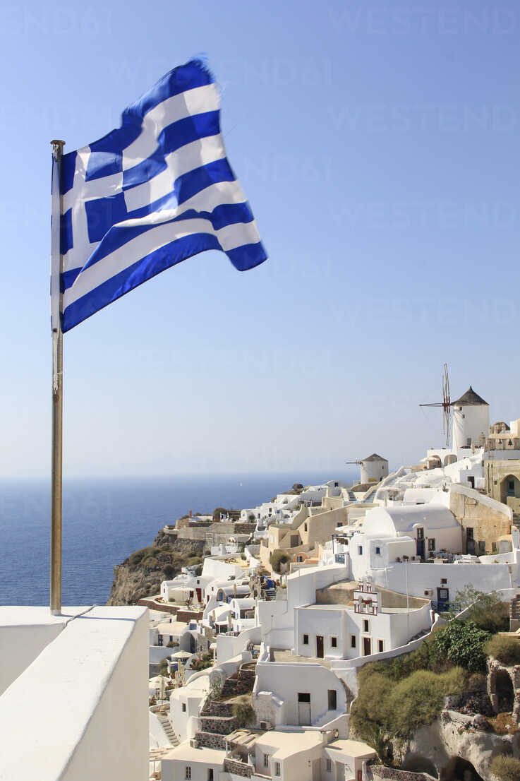Griechische Flagge weht am Meer gegen Stadt und klaren Himmel, lizenzfreies  Stockfoto