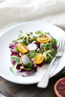 Hochformatige Ansicht von Salat, der in einem Teller auf einem Schneidebrett serviert wird - CAVF51282
