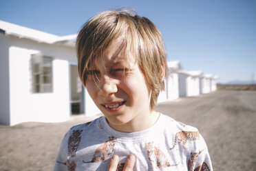 Close-up portrait of boy against houses during sunny day - CAVF51289