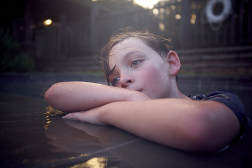 Nahaufnahme eines nachdenklichen Jungen, der am Pool steht und wegschaut - CAVF51303