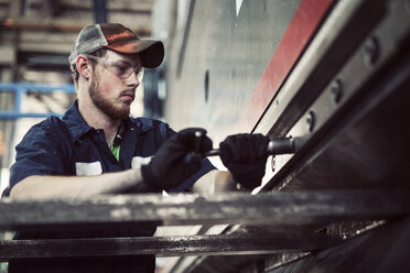 Niedriger Blickwinkel auf einen Mann bei der Arbeit in der Stahlindustrie - CAVF51313