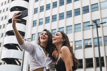 Laughing friends taking selfie with cell phone - KKAF02821