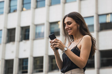 Lächelnde junge Frau mit Mobiltelefon - KKAF02824