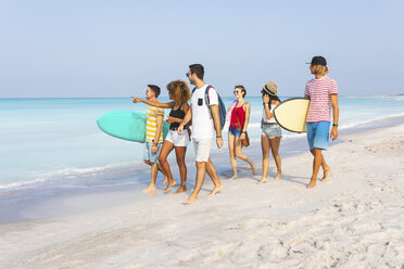 Group of friends walking on the beach, carrying surfboards - WPEF00948