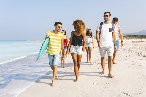 Gruppe von Freunden, die am Strand spazieren gehen und Surfbretter tragen - WPEF00949