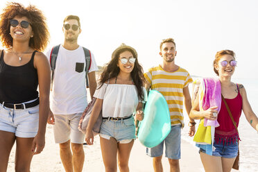 Gruppe von Freunden, die am Strand spazieren gehen und Surfbretter tragen - WPEF00951