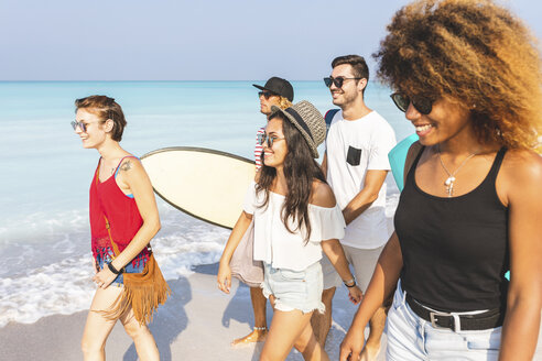 Gruppe von Freunden, die am Strand spazieren gehen und Surfbretter tragen - WPEF00952