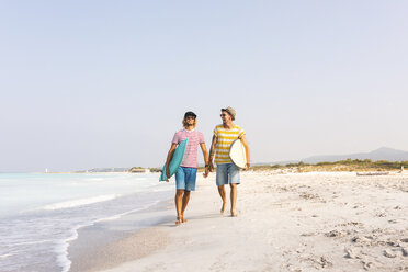 Freunde, die am Strand spazieren gehen und Surfbretter tragen - WPEF00960