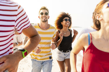 Freunde, die gemeinsam Spaß haben und am Strand laufen - WPEF00969