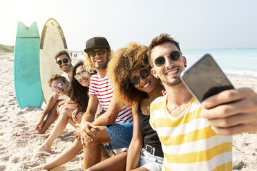 Freunde sitzen am Strand, haben Spaß und machen Selfies - WPEF00975