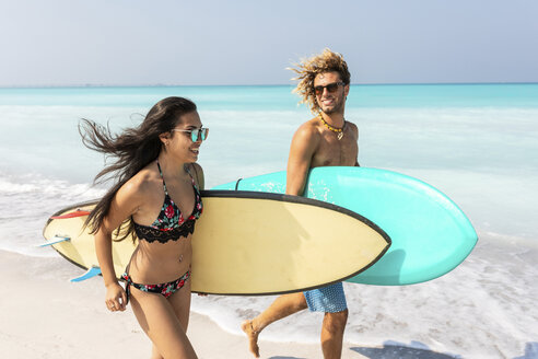 Pärchen läuft am Strand, trägt Surfbretter - WPEF01005