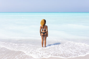 Junge Frau steht am Meer und schaut in die Ferne, Rückansicht - WPEF01039