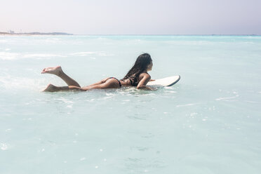 Young woman lying on surfboard, floating on the sea - WPEF01066