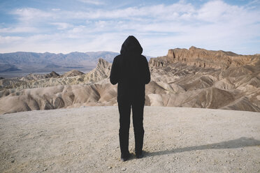 Rückansicht eines Mannes, der auf einem Berg gegen den Himmel im Death Valley National Park steht - CAVF51385