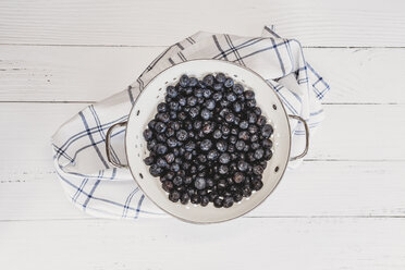 High angle view of blueberries in plate with napkin on wooden table - CAVF51392