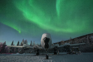 Snow covered airplane against aurora borealis - CAVF51395