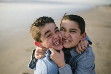 Hochformatiges Porträt von glücklichen Brüdern, die am Strand stehen - CAVF51411