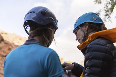 Wanderer tragen Helme beim Lesen eines Reiseführers - CAVF51414