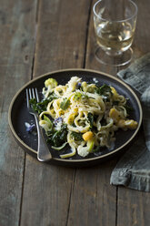 Close-up of spaghetti served in plate by drink on wooden table - CAVF51455