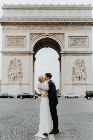 Braut und Bräutigam küssen sich, Arc de Triomphe im Hintergrund, Paris, Frankreich, lizenzfreies Stockfoto
