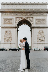 Braut und Bräutigam küssen sich, Arc de Triomphe im Hintergrund, Paris, Frankreich - CUF46342