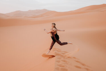 Woman running in desert, Douba, Morocco - CUF46348
