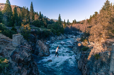 Man highlining above river, Truckee, California, USA - CUF46430