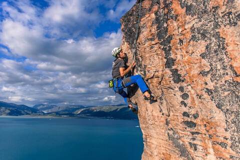 Mann beim Klettern, Narsaq, Vestgronland, Südgrönland, lizenzfreies Stockfoto