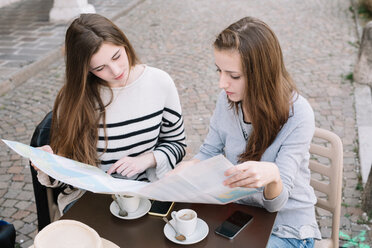 Girlfriends reading street map at cafe - CUF46462
