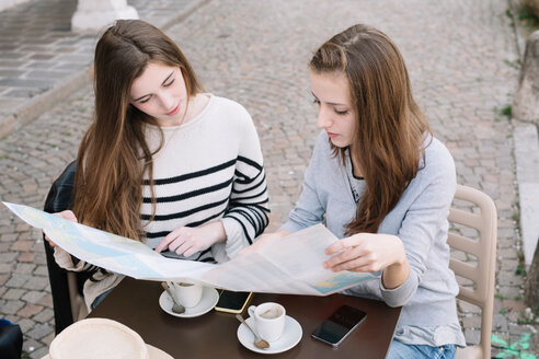 Freundinnen lesen Straßenkarte im Café - CUF46462