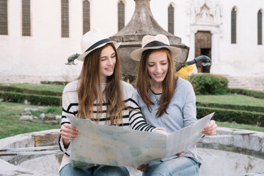 Freundinnen lesen Straßenkarte auf der Piazza, Belluno, Venetien, Italien - CUF46463