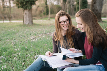 Girlfriends reading book in park - CUF46470