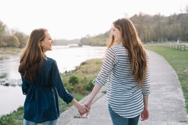 Girlfriends taking walk by river, Belluno, Veneto, Italy - CUF46489