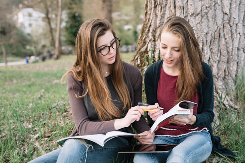 Freundinnen lesen ein Buch im Park - CUF46495