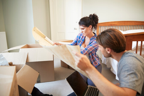 Ehepaar liest Bauplan im neuen Haus, lizenzfreies Stockfoto