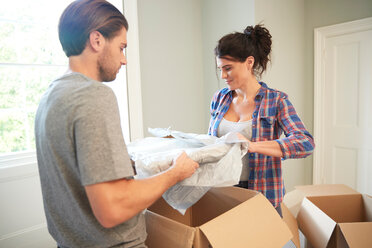Couple packing belongings into cardboard box - CUF46525