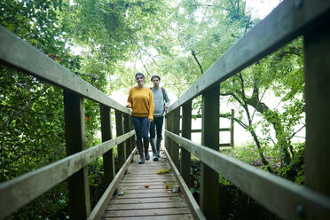 Hiker couple crossing wooden bridge - CUF46531