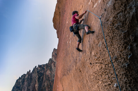 Mann beim Klettern, Smith Rock State Park, Oregon, USA, lizenzfreies Stockfoto