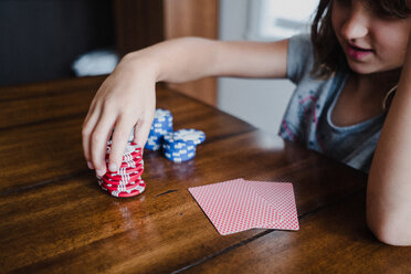 Mädchen spielt Karten am Tisch, stapelt Glücksspielchips, Nahaufnahme - ISF20036
