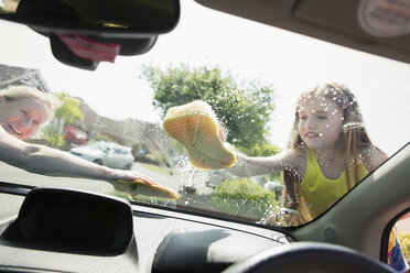 Mutter und Tochter waschen die Windschutzscheibe eines Autos - CAIF22190