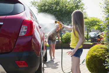 Mutter und Tochter waschen Auto in sonniger Einfahrt - CAIF22196