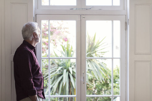 Nachdenklicher älterer Mann schaut aus dem Fenster - CAIF22215